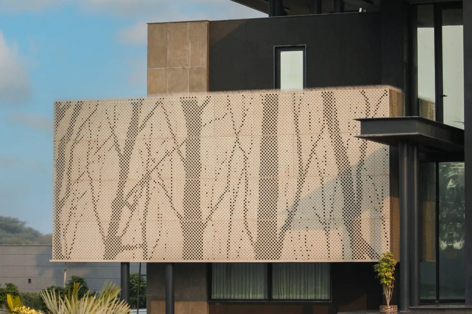 CNC-perforated metal cladding creating a patterned architectural screen at the Rewari Farm project.